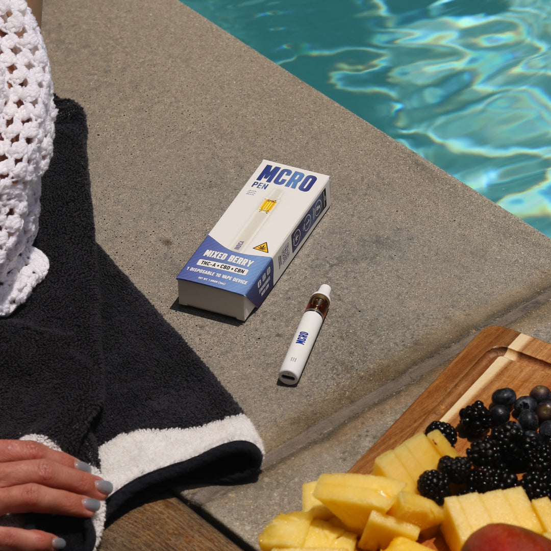 1 Gram Disposable Vape - Mixed Berry Indica - Poolside Product Shot with Fruit - MCRO Edibles in the U.S.